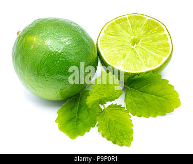 Un ensemble d'un demi citron vert frais et feuilles de mélisse isolé sur fond blanc Banque D'Images