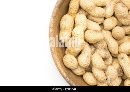 Les arachides de l'Unshelled Vue de dessus dans un bol en bois isolé sur fond blanc Banque D'Images