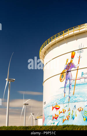 Le changement climatique le ciel et l'enfer, un terminal pétrolier à Amsterdam, Pays-Bas, avec des éoliennes produisant de l'énergie renouvelable. Aussi un grand exemple de green washing avec happy fish rond dépeint un pétrolier. Banque D'Images