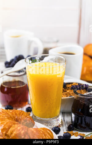 Le jus d'Orange. Petit-déjeuner continental avec des croissants, du café, des céréales et des fruits. Banque D'Images