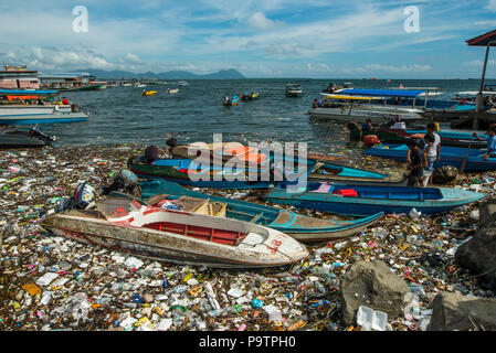 La pollution en plastique à côté de petits bateaux flottants au bord de l'eau dans Semporna town à Sabah, Malaisie (Bornéo), Malaisie. Banque D'Images