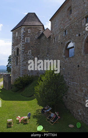 Slovénie : woman relaxing, chaises longues, des coussins colorés et des décorations sur une pelouse verte dans le château de Ljubljana (Ljubljanski Grad), forteresse médiévale Banque D'Images