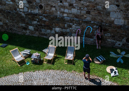 Slovénie : personnes, chaises, des coussins colorés et des décorations pour se détendre sur une pelouse verte dans la forteresse médiévale, château de Ljubljana Banque D'Images