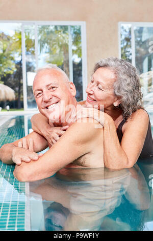 Happy senior couple dans la piscine jouissant ensemble de l'espace bien-être locations Banque D'Images