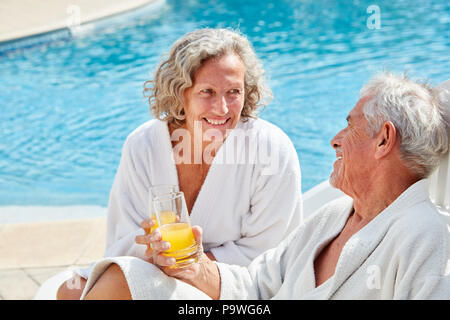 Couple se détend au bord de la piscine avec un spa locations Banque D'Images