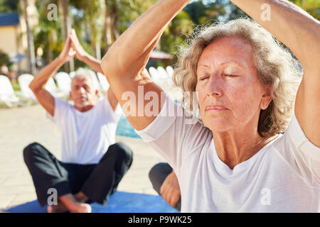 Vieille Femme assise et médite dans le spa de la piscine, dans une classe de yoga ou de l'atelier Banque D'Images