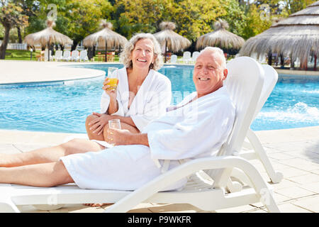 Professionnels Seniors couple de détente à la piscine de l'hôtel spa de luxe Banque D'Images