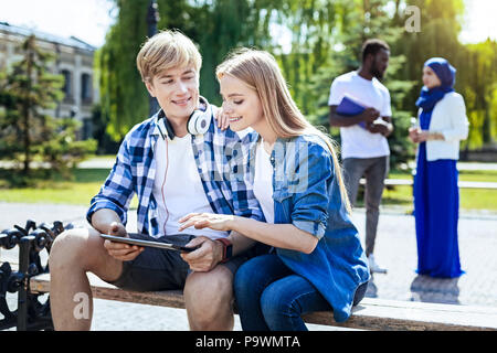 Collège détendu et souriant à l'extérieur chat mates Banque D'Images