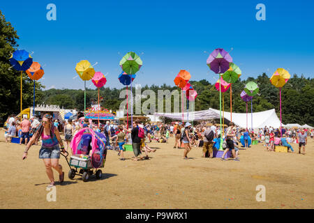 Femme avec des dreadlocks multicolores et de teintures vest top tire un bébé multicolore-buggy jusqu'à la colline dans la principale zone de latitude au showground Festiva Banque D'Images