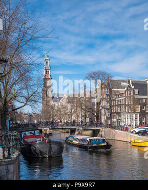 Nombreux vélos sur un pont surplombant un canal à Amsterdam, Pays-Bas, Europe avec un bateau sous voile Banque D'Images