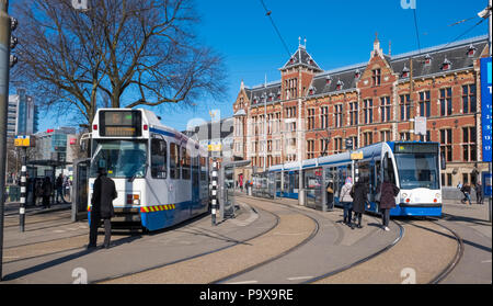 Les tramways circulent à l'extérieur de la Gare Centrale d'Amsterdam, Amsterdam, Pays-Bas, Hollande, Europe Banque D'Images