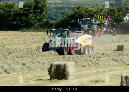 La mise en balles de la machine au moment de la récolte, pressage de paille sur une ferme à Dartmoor, dans le Devon, England, UK Banque D'Images