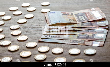 50 billets et 1 pièces en euro sur un fond en bois clair. Banque D'Images