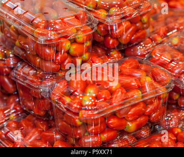 Tomates cerises en récipients en plastique sur l'affichage dans les épiceries. Isolées. Image Banque D'Images