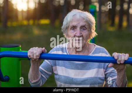 Portrait d'une femme âgée de faire des exercices matinaux sur l'aire de sport de rue. Banque D'Images