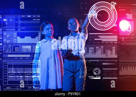 Garçon calme tenant un smartphone et pointant vers l'écran Banque D'Images