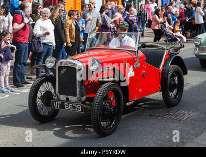 Une voiture rouge vintage Austin prend part à l'assemblée annuelle peut Day Parade dans le centre-ville de Penrith en Cumbria, Angleterre. Banque D'Images