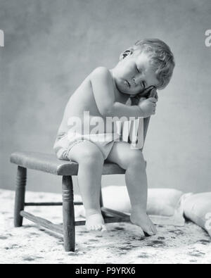 Années 1920 Années 1930 TOUT-PETITS BÉBÉ FATIGUÉ PORTANT COUCHE EN TISSU DE COTON SONT ENDORMIS SITTING IN CHAIR - b10392 HAR001 HARS TOMBÉ SIESTE DANS QUARANTE WINKS BABY BOY 40 WINKS JUVÉNILES RELAXATION PAN NOIR ET BLANC DE L'ORIGINE ETHNIQUE CAUCASIENNE HAR001 old fashioned Banque D'Images