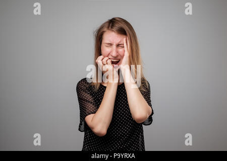 Femme européenne dans le stress est fou tirant ses cheveux dans la frustration. L'émotion du visage négatif Banque D'Images