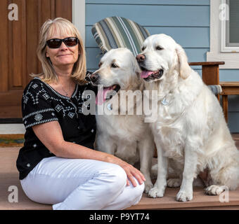 Portrait d'une femme avec ses deux beaux chiens Golden Retriever de couleur platine ; Salida, Colorado, USA Banque D'Images