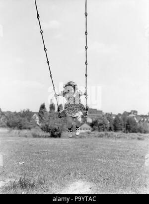 Années 1930 Années 1940 GIRL OUTDOOR LE JEU POUR ENFANTS SWING - j1108 HAR001 HARS SCENIC B&W L'ÉTÉ CONTACT AVEC LES YEUX le bonheur d'excitation de l'ANGLE FAIBLE CROISSANCE JOYEUX SOURIRES JUVÉNILES OSCILLANTE NOIR ET BLANC DE L'ORIGINE ETHNIQUE CAUCASIENNE HAR001 old fashioned Banque D'Images