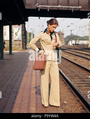 1970 FEMME IMPATIENTE ATTENTE DE LA FIN DE LA FORMATION SUR LA PLATE-FORME PORTE UN PANTALON COSTUME HOLDING BRIEFCASE À la montre-bracelet - KR28731 À HAR001 Vente de la plate-forme de HARS longtemps retardée RETARD CONCEPTUEL PROFESSIONS VENDEUSE VENDEUSE & commerçante d'affaires élégant CHEMINS RETARD IMPATIENT MID-ADULT MID-ADULT WOMAN EN RETARD l'origine ethnique caucasienne TARDY HAR001 old fashioned Banque D'Images