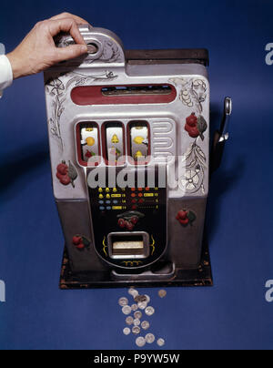 1950 HOMME HAND INSERTING COIN EN ARGENT REEL trois anciens bandit manchot SLOT MACHINE - KS3046 DUN001 LOISIRS HARS de répandre sans contradiction CONCEPTUELLE STILL LIFE GAMBLE CASINO SPADES CERISES FERS INVENTEUR LIBERTY BELL ORANGES BANDIT Logement en métal moulé de PARI CHANCE JEU DE HASARD MÉCANISME CITRONS vieux jeu bandit manchot Banque D'Images