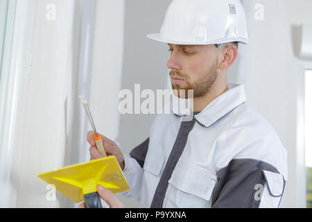 Artisan boucher les fentes dans le mur Banque D'Images