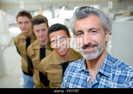 Le professeur posant avec les étudiants de formation professionnelle Banque D'Images