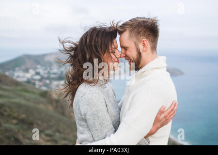 Close-up portrait of couple avec le vent dans les cheveux, serrant et heureux ensemble. Dans les deux pulls Banque D'Images