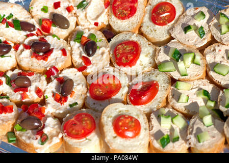 Variété de mini sandwiches au fromage, crème de légumes - tomates cerises grillées, olives, concombres, oignons, paprika, basilic et autres herbes. F Banque D'Images