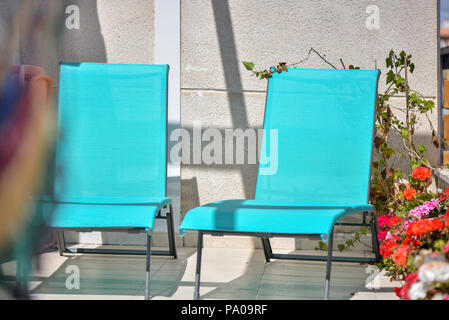 Les lits de bronzage ou des chaises sur une terrasse de toit villa près de la mer côté. Fleurs en fleurs tout autour. Profitez de l'été vacances et locations. C Banque D'Images