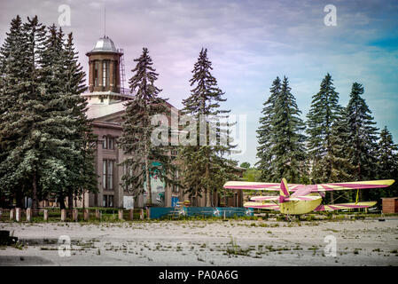 Un vieil avion jaune et rose dans un aéroport abandonné à côté de forêt sombre dans l'image. Avion militaire, ancien avion russe. Produire en masse soviétique Banque D'Images