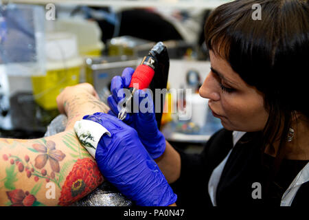 Une jeune femme se fait tatouer le bras par une artiste espagnole de tatouage Beatriz Villacorta dans son studio de tatouage local à Dundee, en Écosse Banque D'Images