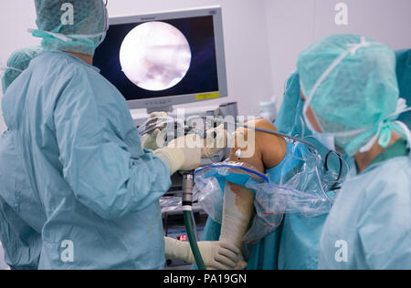 Munich, Allemagne. 19 juillet, 2018. Un médecin opérant sur un genou du patient dans le service de chirurgie orthopédique de l'OCM (Munich). Le patient a été équipé avec un ligament croisé de remplacement - qui a été préparé par l'un des tendons du patient lui-même - au cours de la chirurgie (arthroscopie). Crédit : Sven Hoppe/dpa/Alamy Live News Banque D'Images