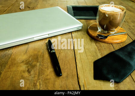 Business desktop , espace de travail avec ordinateur portable,tasse de café,cravate et stylo sur la table en bois. Banque D'Images