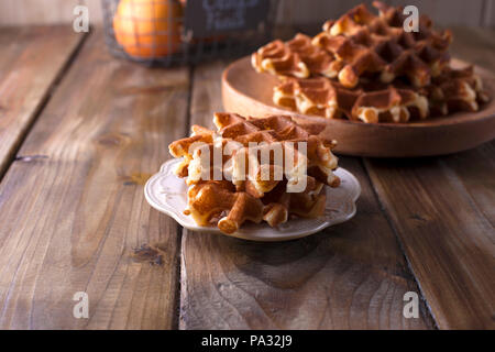 Gaufres sucrées pour le petit-déjeuner, sur une plaque de bois. Sur un fond de bois brun Banque D'Images