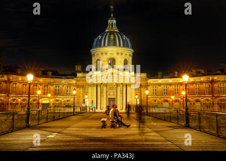 Pont Pont des Arts à l'Institut de France, la construction d'une société savante française groupe des cinq académies. Crossing bridge point de vue avec des gens à Paris, France. Scène de nuit. Banque D'Images