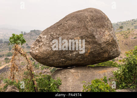 Un énorme rocher perché au sommet d'une montagne surplombant une vue pittoresque sur le paysage, les arbres et le ciel. Banque D'Images