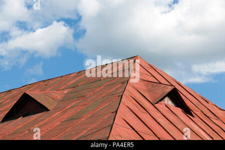 Old Red metal toit du bâtiment contre le ciel bleu, beaucoup de dégâts sur le métal, gros plan Banque D'Images
