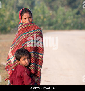 Une mère asiatique timide debout avec son enfant s'accrochant dans Bandhavgarh National Park, Inde Banque D'Images