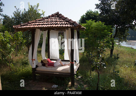 Un lit à baldaquin est pour les clients de l'hôtel, qui voudraient faire l'expérience de dormir à la belle étoile, dans le Parc National de Kanha, India Banque D'Images