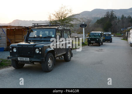 Une rangée de trois véhicules Land Rover Defender en stationnement le long de la route principale dans la ville de Inverie, dans la péninsule de Knoydart, Ecosse, Royaume-Uni. Banque D'Images