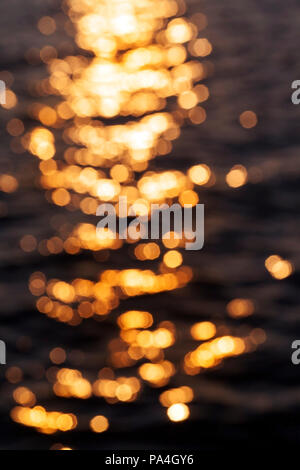 Surface noire de l'eau avec des vagues du vent, l'heure du jour au crépuscule, close-up, la surface est flou et sur l'eau il y a une séquence avec l'éblouissement Banque D'Images
