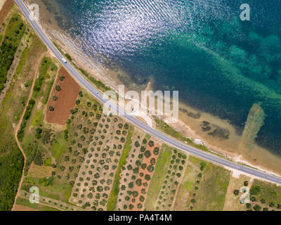 Vue aérienne d'une route qui longe la côte croate et passe à travers des champs agricoles, avec les plantations et les champs cultivés. Littoral Banque D'Images