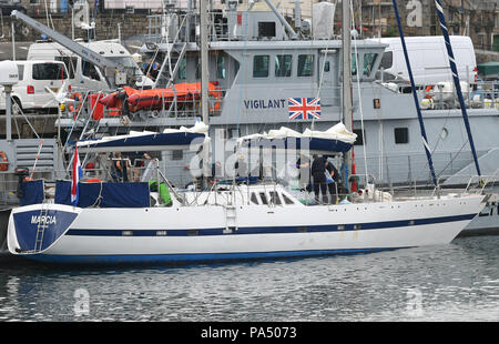 Les drogues sont déchargées d'un bateau par les agents au sein du port de Newlyn, avec force la frontière HMC cutter vigilants derrière, après l'Agence nationale de lutte contre la criminalité ont saisi un yacht à voile dans la Manche et l'a achetée à l'Harbour et arrêté deux hommes soupçonnés de trafic de drogue. Banque D'Images