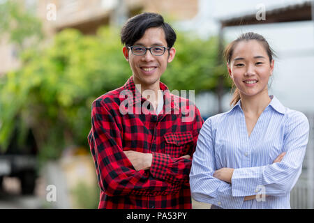 Young happy Asian couple together outdoors Banque D'Images