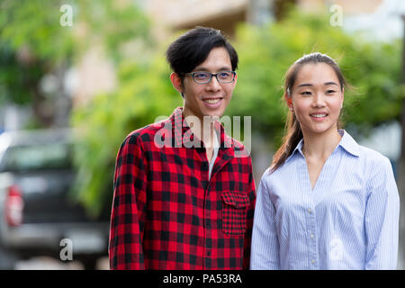 Young happy Asian couple together outdoors Banque D'Images