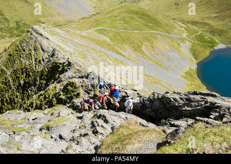 Groupe de Randonnée Les randonneurs et des mains sur le bord vif ces échelles Tarn sur Blencathra montagne en montagne Parc National de Lake District Cumbria England UK Banque D'Images