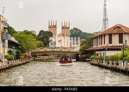 Malacca, Malaisie - 15 déc 2017 : les touristes en bateau sur le canal en face de l'Église catholique de Saint François Xavier, destination touristique populaire de Mala Banque D'Images